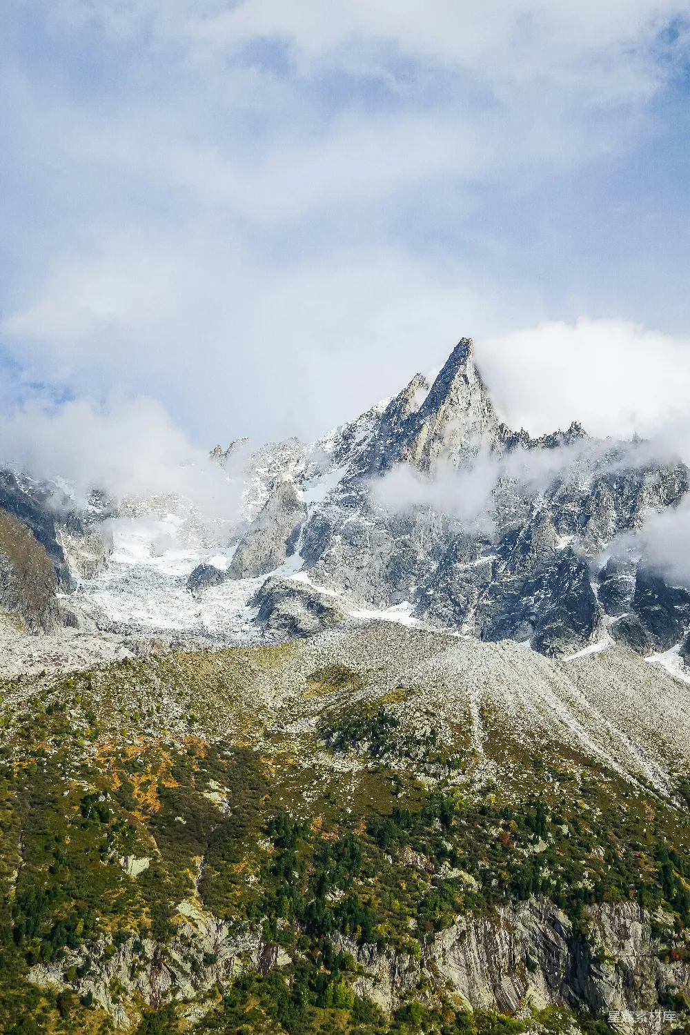 高清摄影  被雪覆盖的山峰，天空中有云。