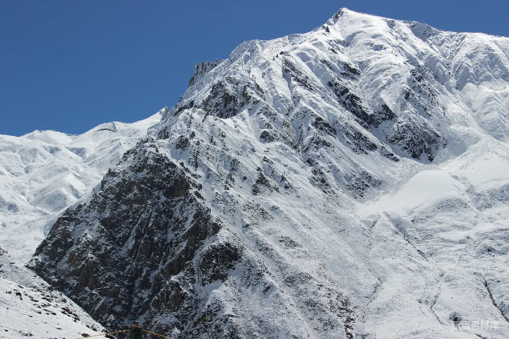 高清摄影  一座被雪覆盖的大山在蓝天的映衬下