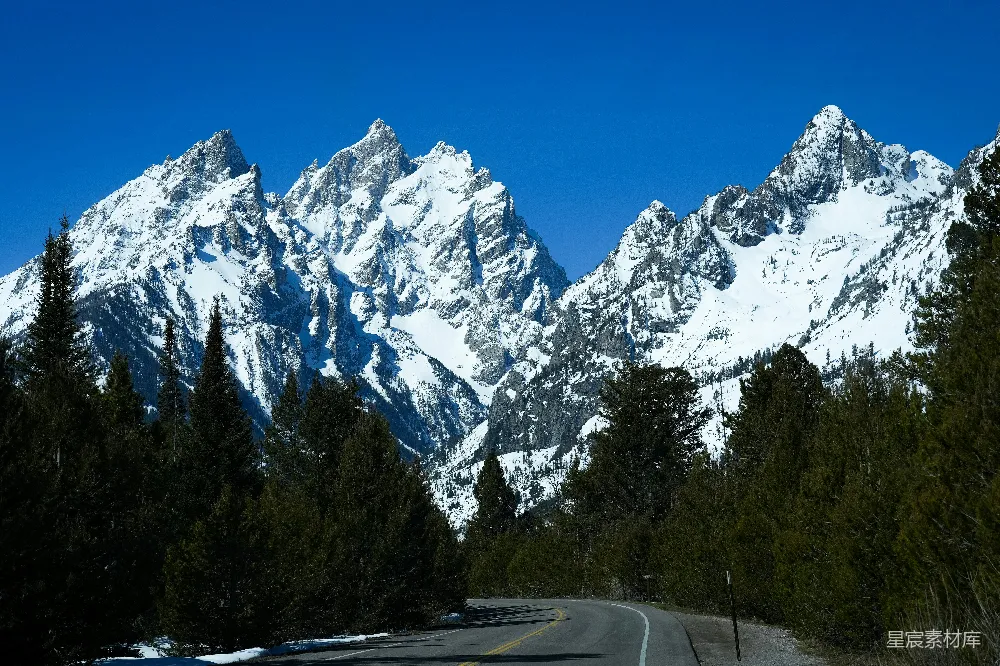 高清摄影  一条雪覆盖的山脉背景的道路