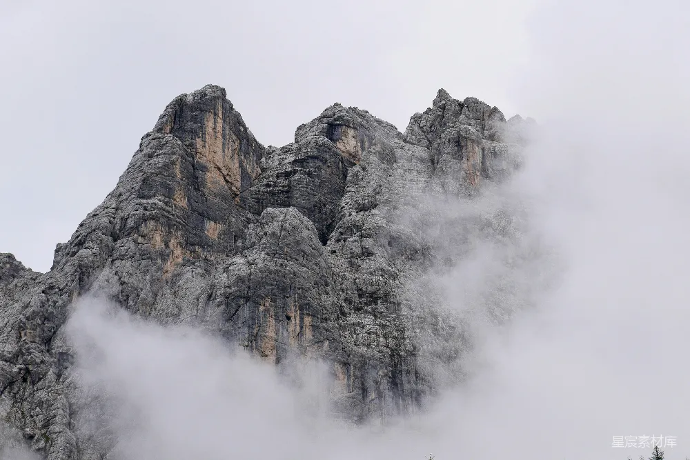 高清摄影 自然 灰白色的岩石山峰上覆盖着白云。