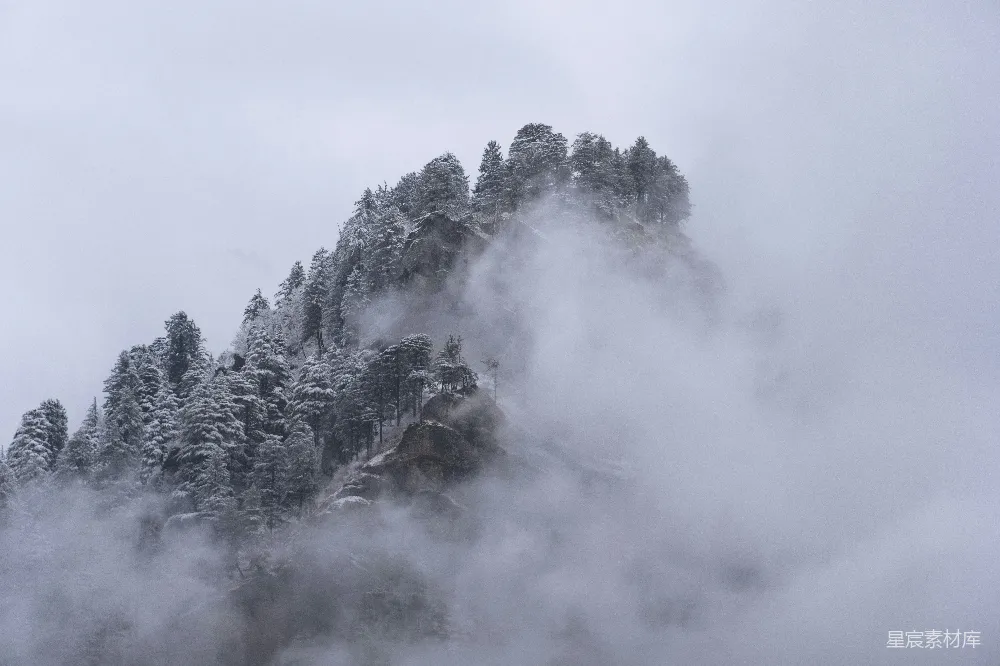 高清摄影  在多云的日子里，一座被雪和雾覆盖的山。