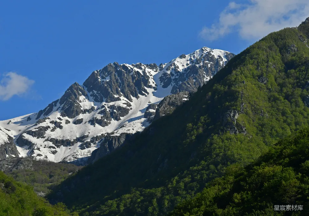 高清摄影  白雪覆盖的山峰，绿色的山坡。