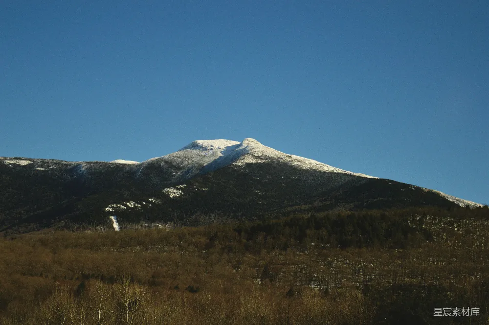 高清摄影 自然 壁纸 一座覆盖着雪的山峰位于田野中间。