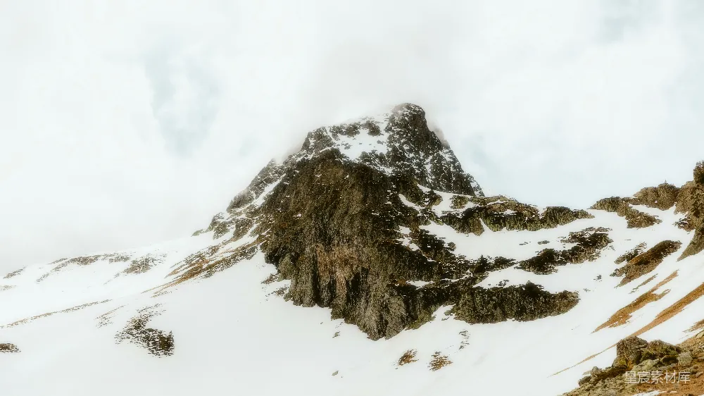 高清摄影  一座被雪覆盖的山峰，背景是天空。