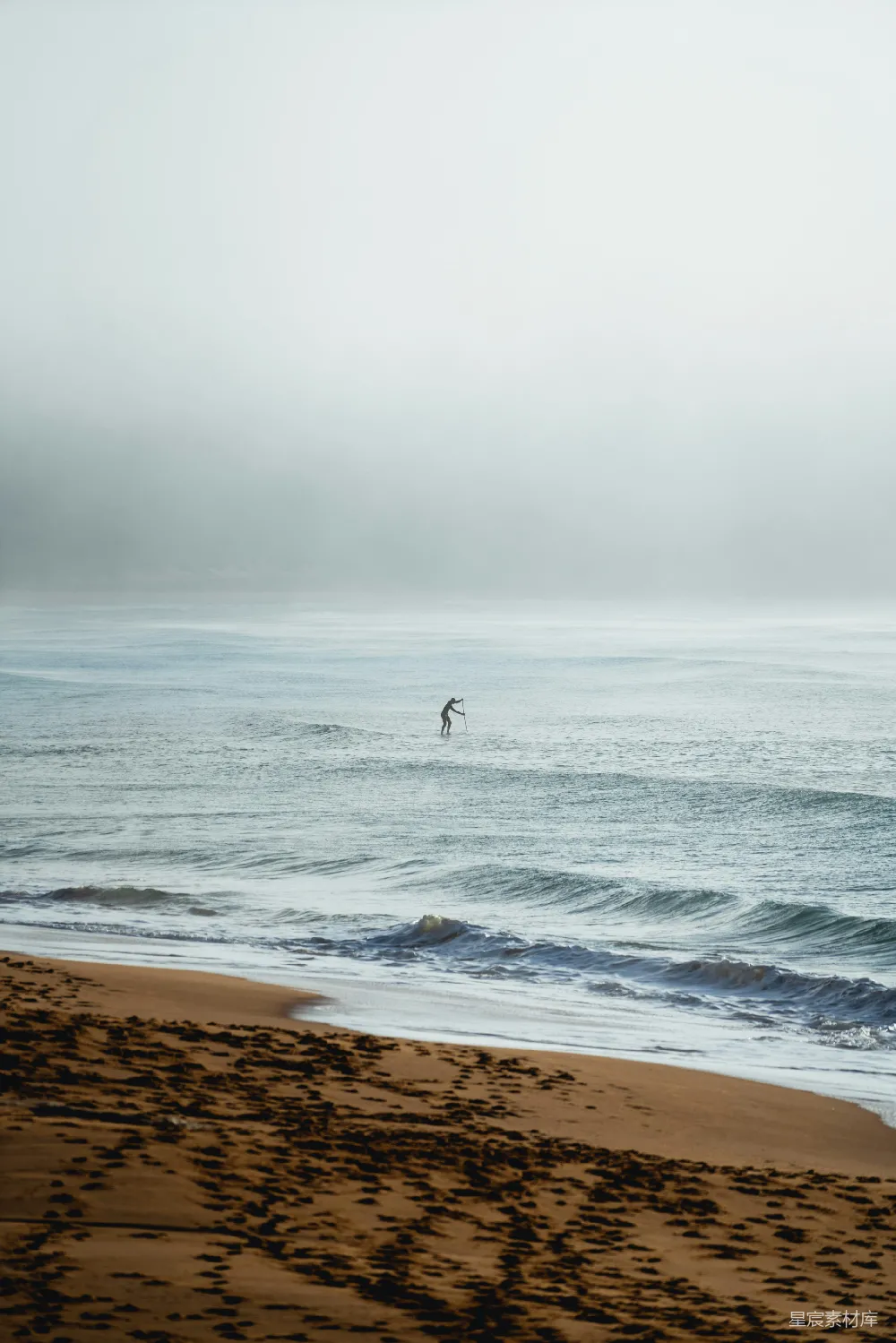 高清摄影  穿着黑色潜水服的人在白天的海滩上行走。