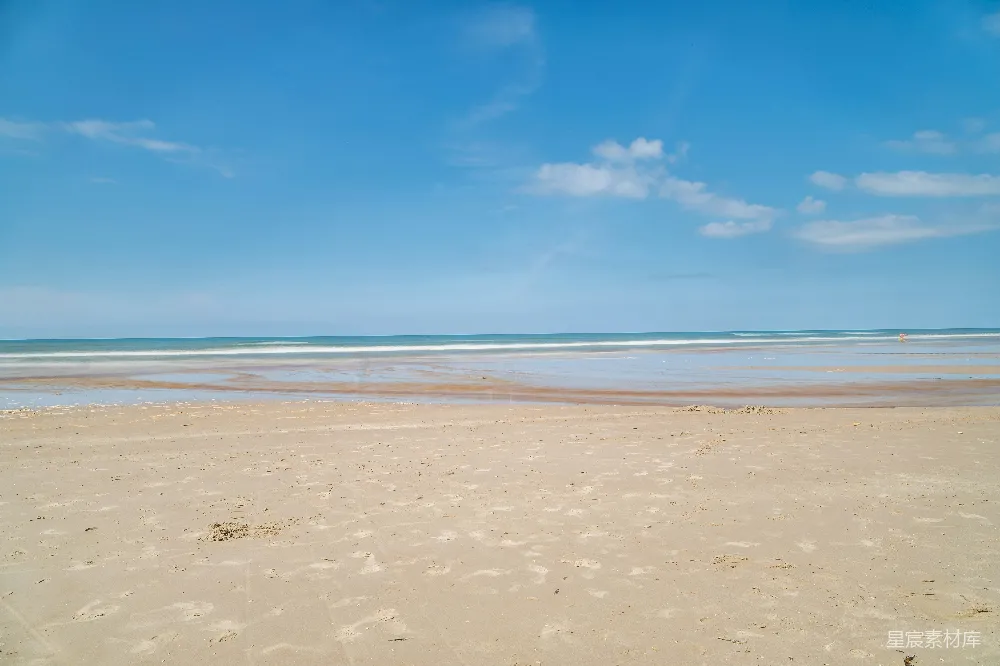 高清摄影  一个沙滩，海浪拍打着海岸。