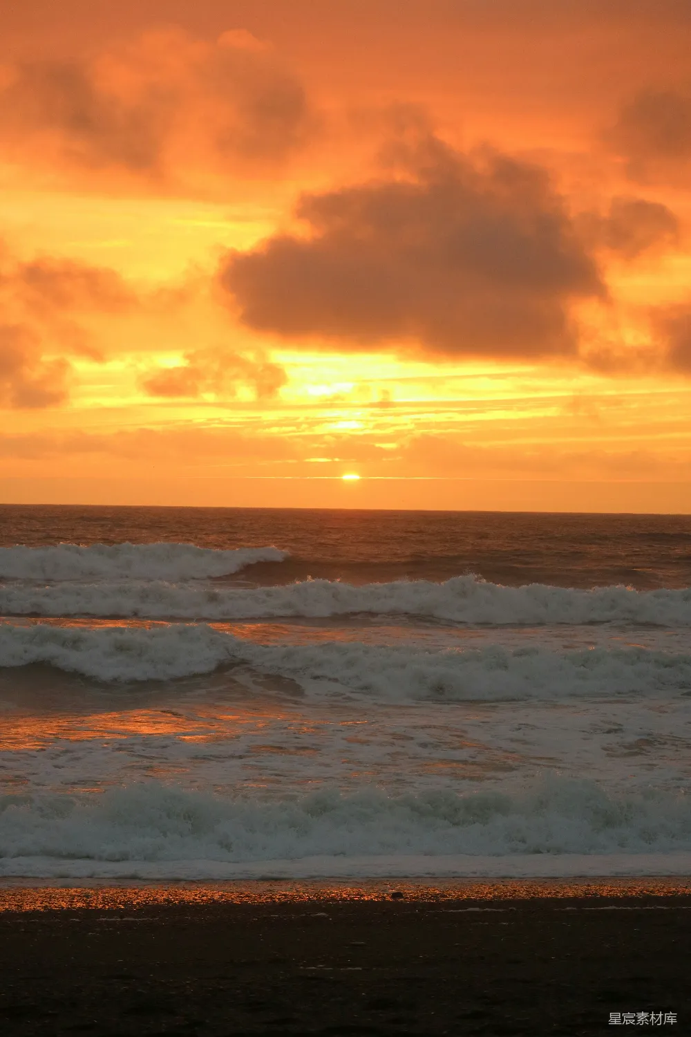 高清摄影  夕阳正照耀在海洋上，海浪轻轻拍打着岸边。