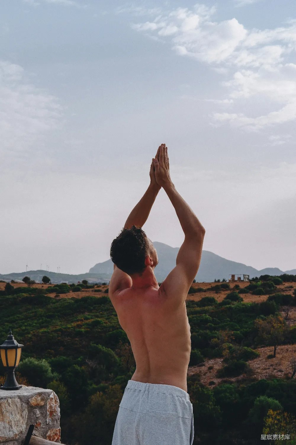 高清摄影  一个男人把手举在空中，位于一个山谷之上。