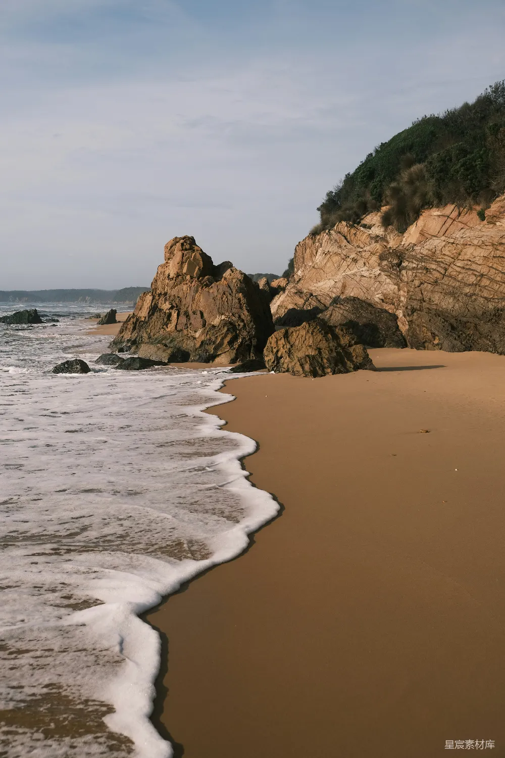 高清摄影  一个沙滩，海浪拍打着海岸。