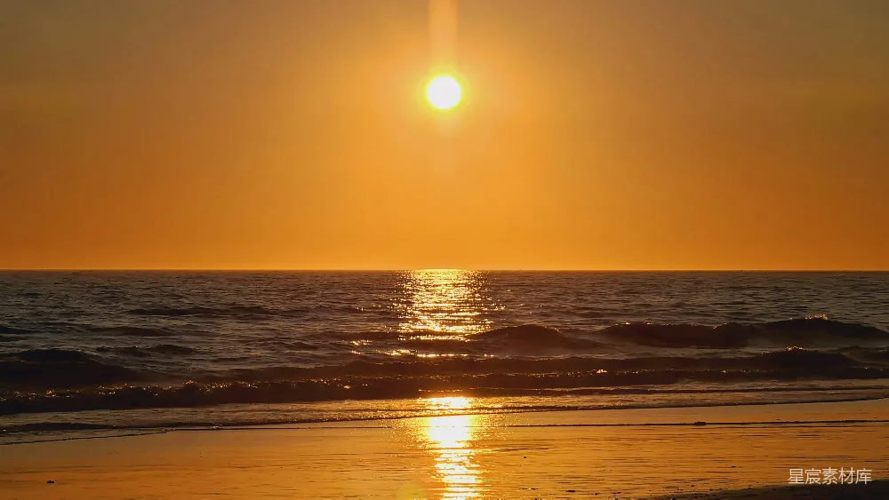 高清摄影  夕阳正悬挂在海面上，在海滩上落下。