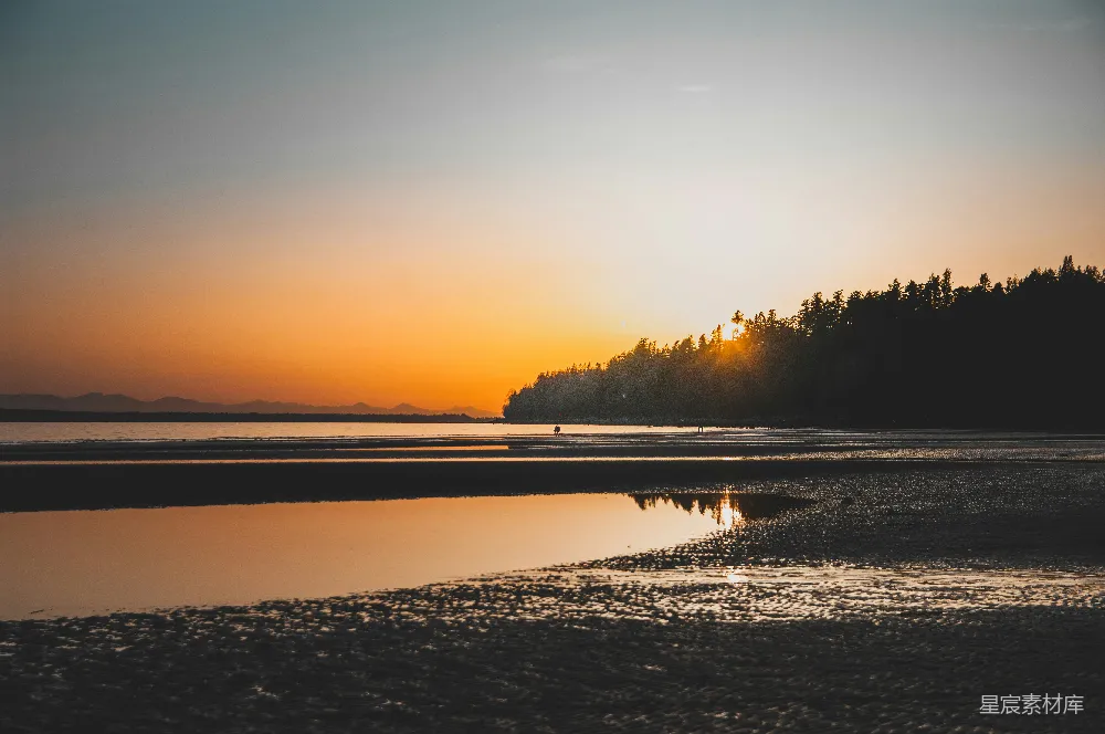 高清摄影  夕阳在海滩的水面上缓缓落下。