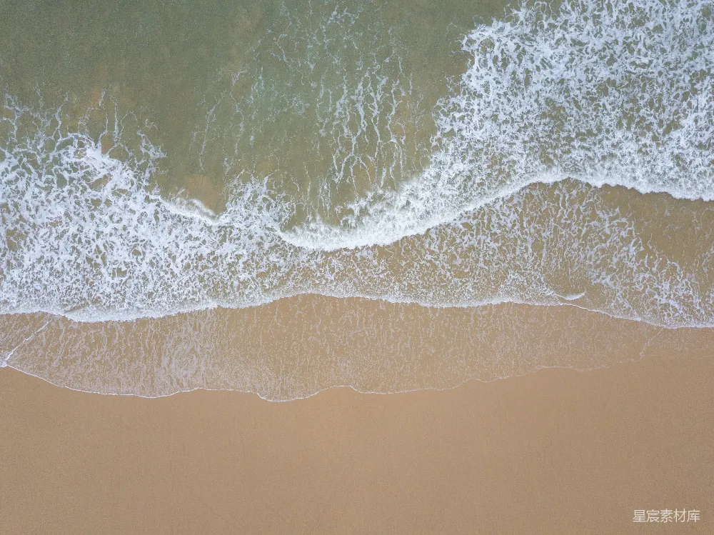 高清摄影  海滩上空鸟瞰图，海浪正涌向岸边。