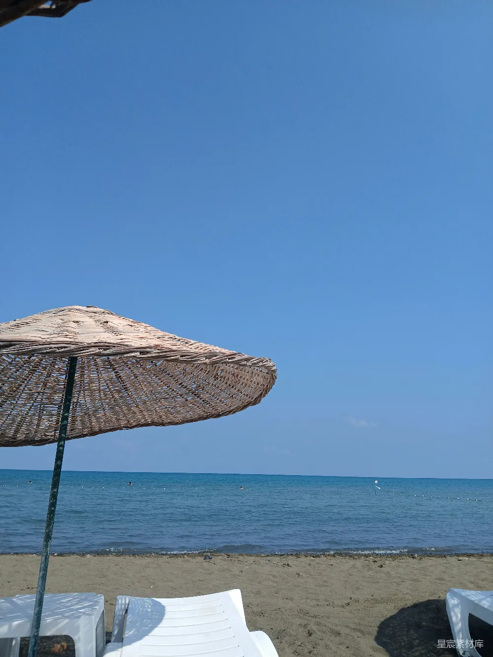高清摄影  几把户外椅子放在海滩上。