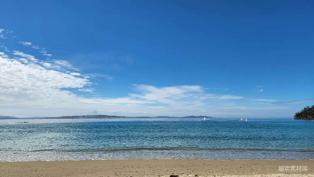 高清摄影 自然 海滩上有一片水域，水上停泊着几艘船。