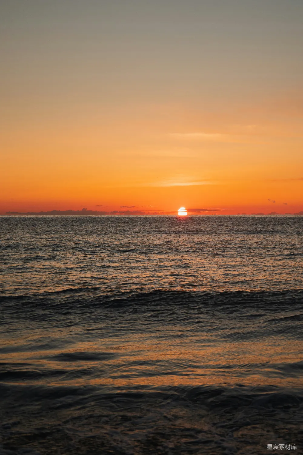 高清摄影  夕阳映照着大海，远处有一艘船。
