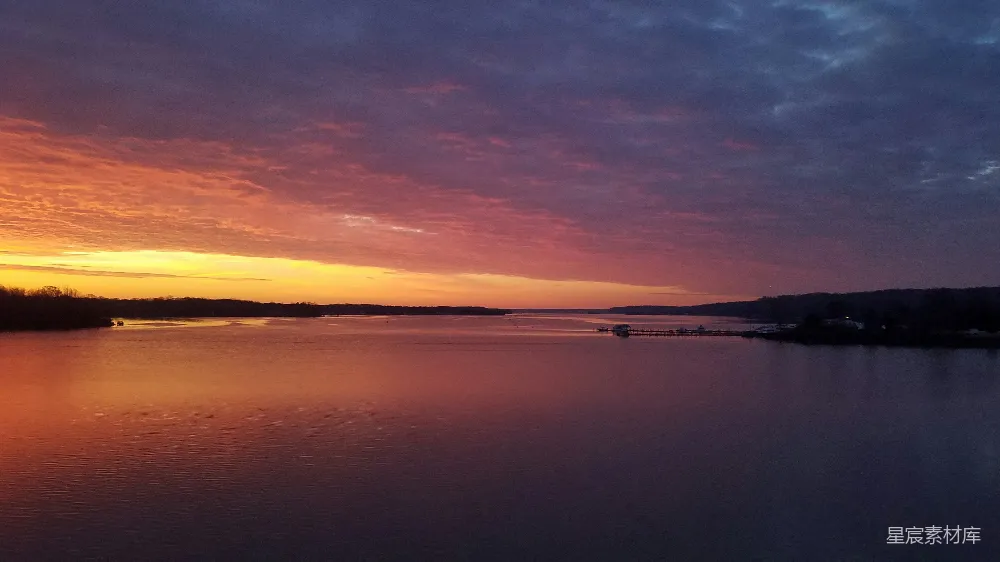 高清摄影  夕阳西下，水面上有一艘船在远处。