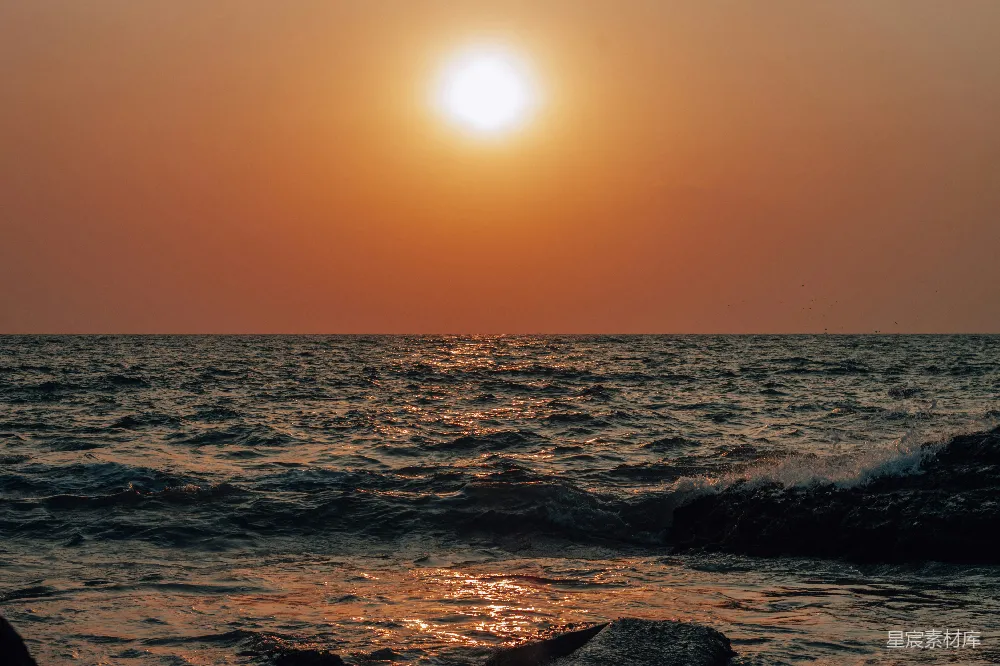 高清摄影  海浪拍打岩石的场景，在夕阳下