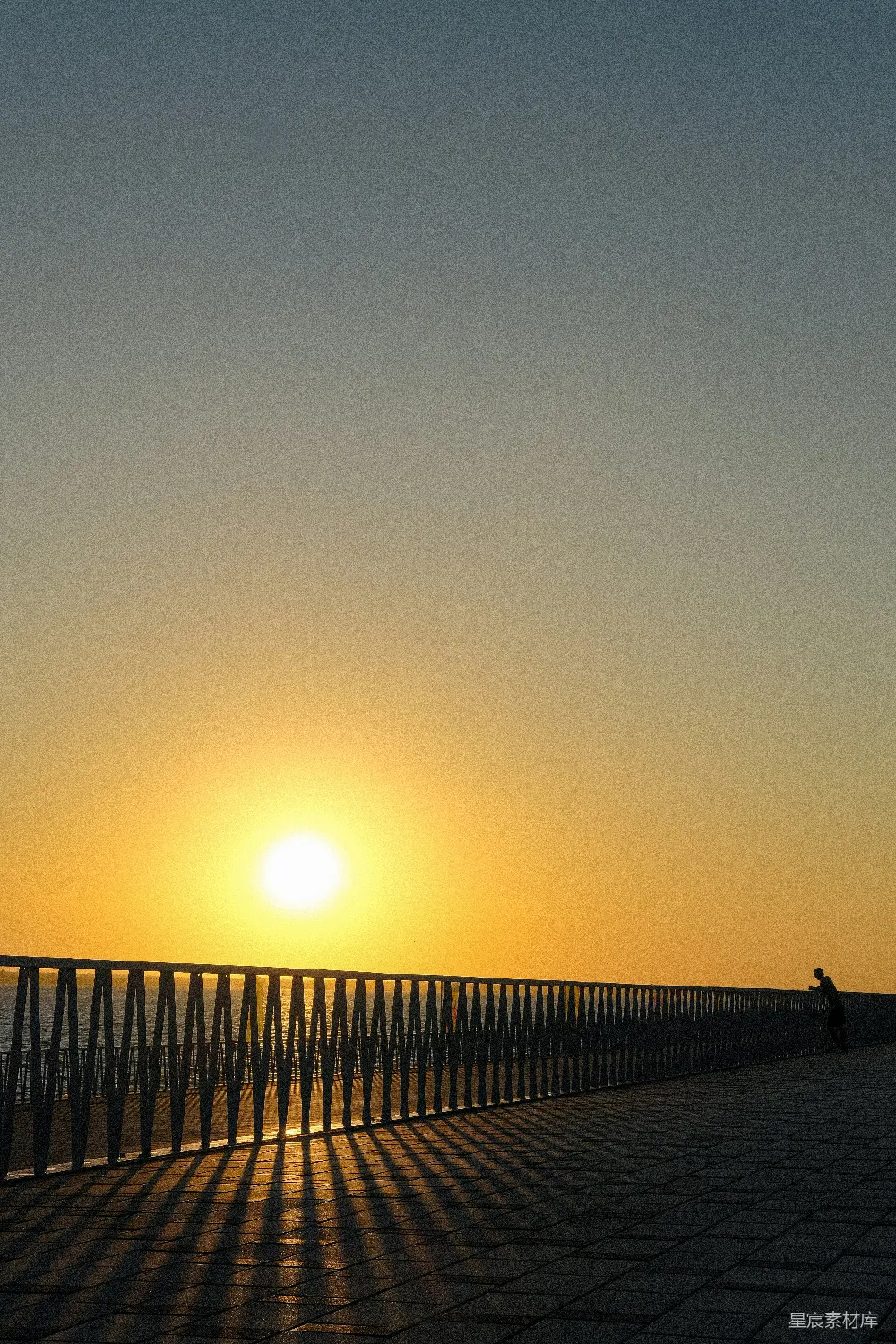 高清摄影  落日洒满海面，长长的栅栏在夕阳下显得格外静谧。