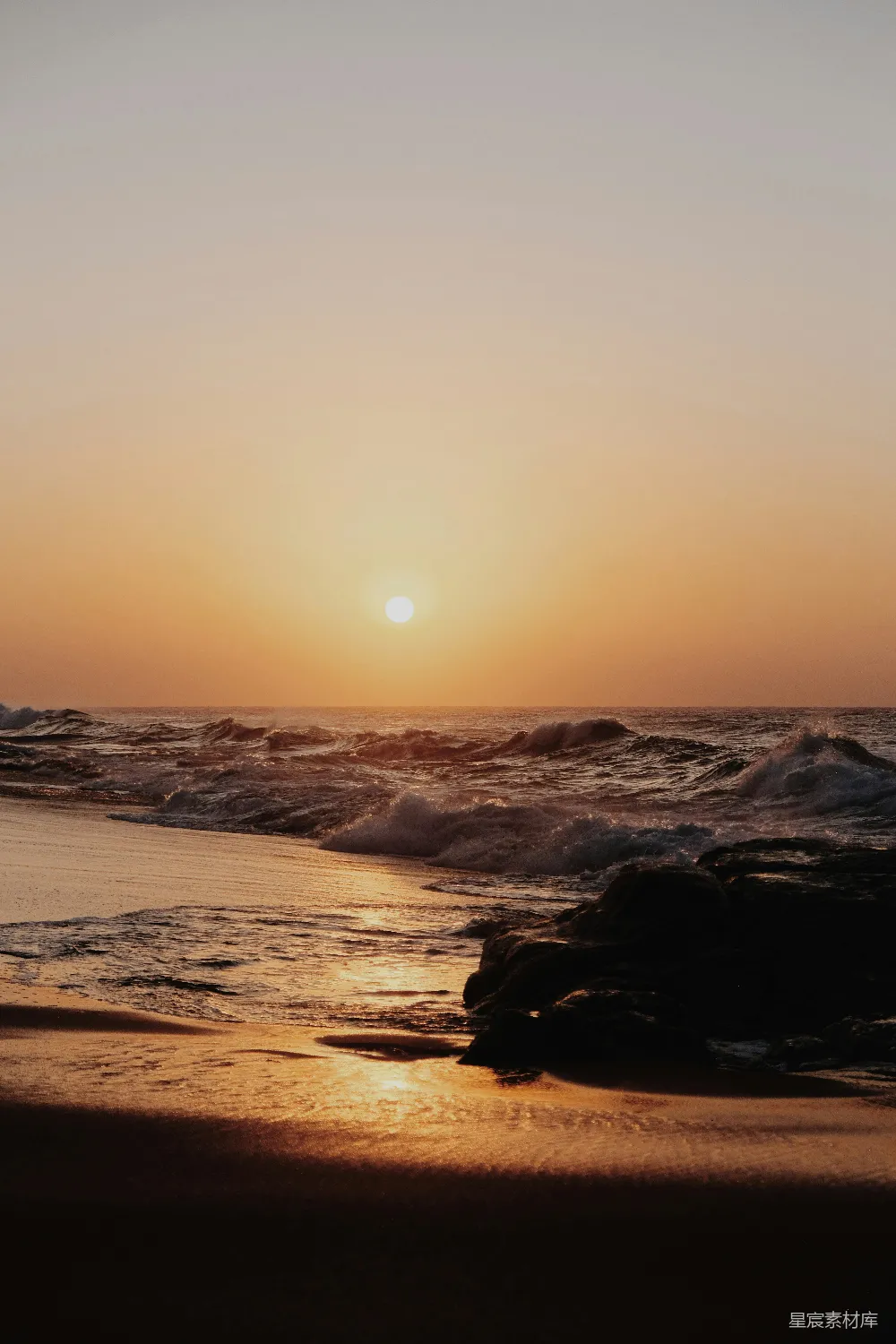 高清摄影  夕阳正照耀在海滩的水面上。