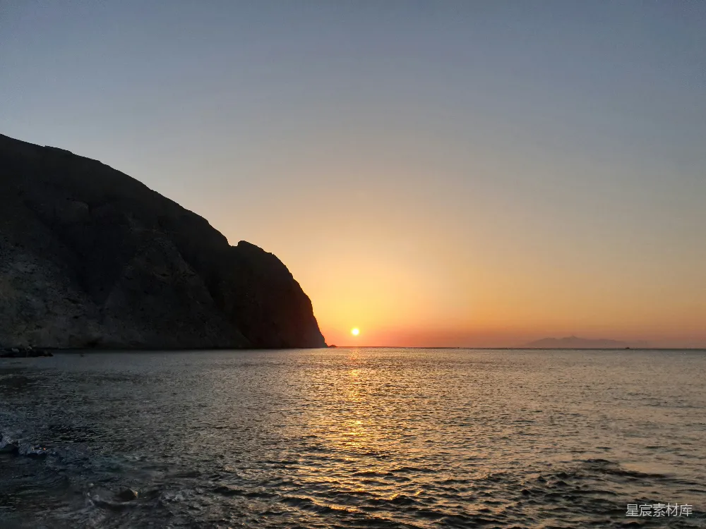 高清摄影  夕阳下海旁山的剪影