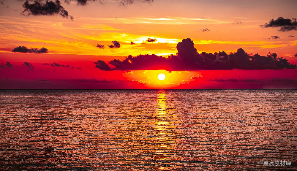 高清摄影  夕阳映照在水面上，云朵漂浮其间。