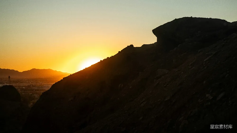 高清摄影  夕阳正照耀着一座岩石山巅。