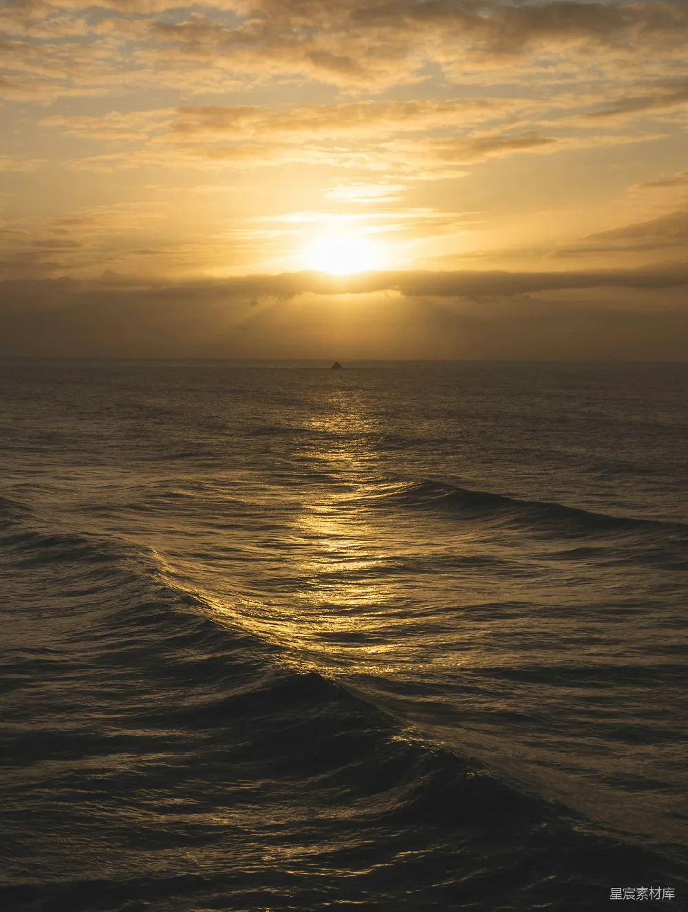 高清摄影  夕阳正在海面上落下，海浪轻轻拍打着。