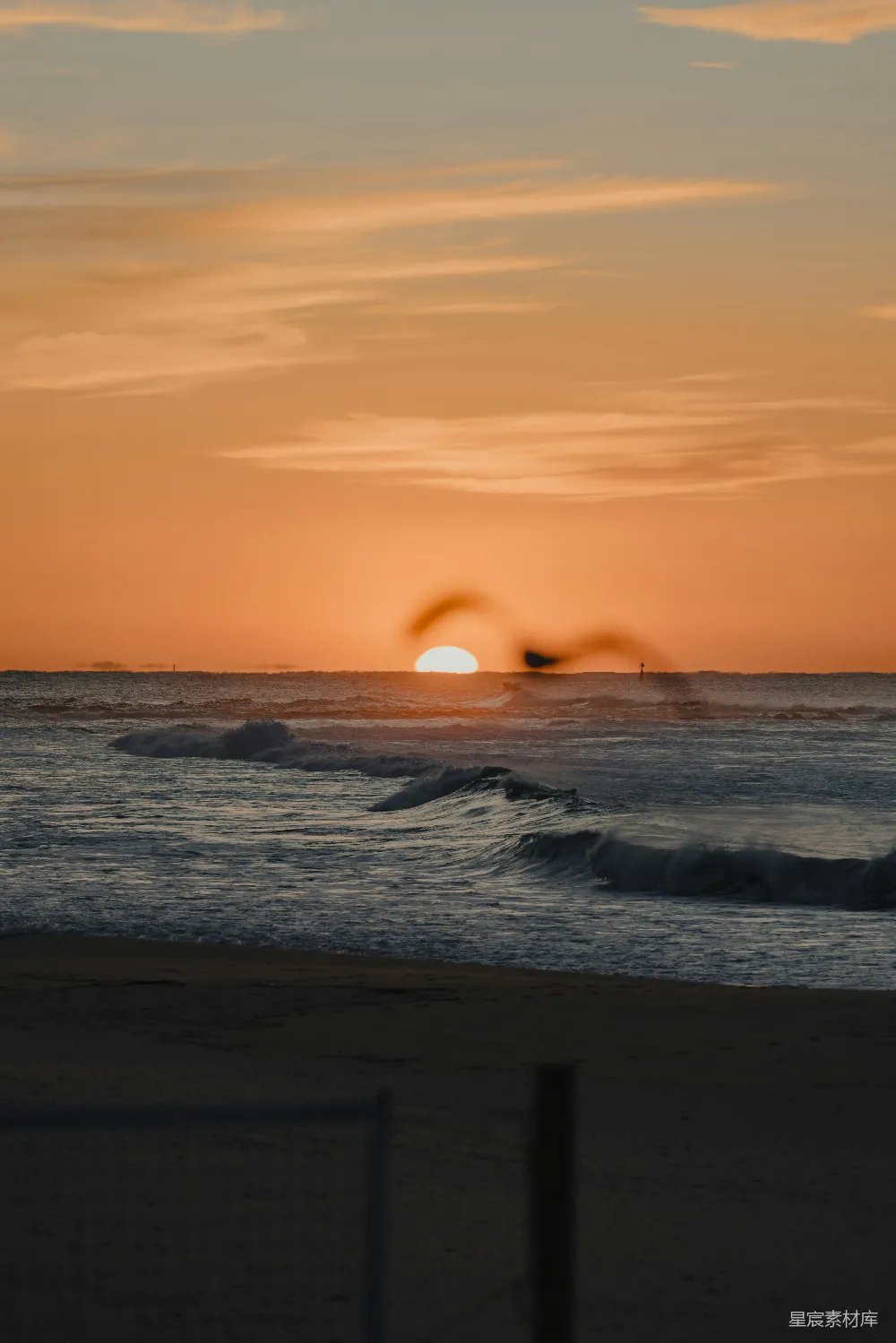 高清摄影  夕阳正在海洋上落下，海浪拍打着岸边。