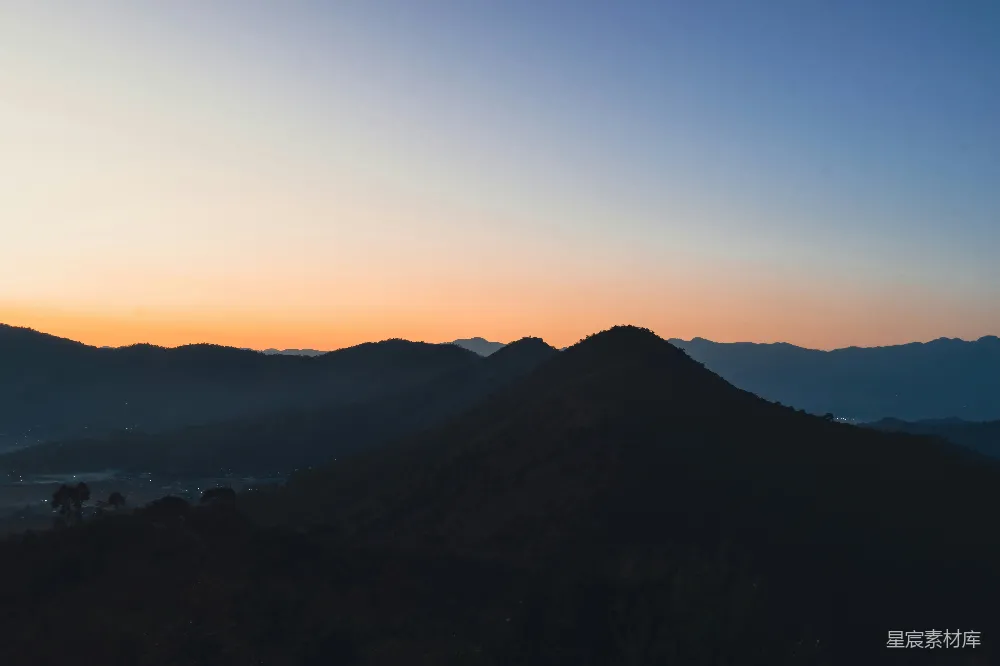 高清摄影  一幅山脉的景色，背景是夕阳。