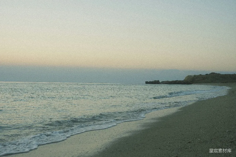 高清摄影  一个沙滩，海浪拍打着海岸。