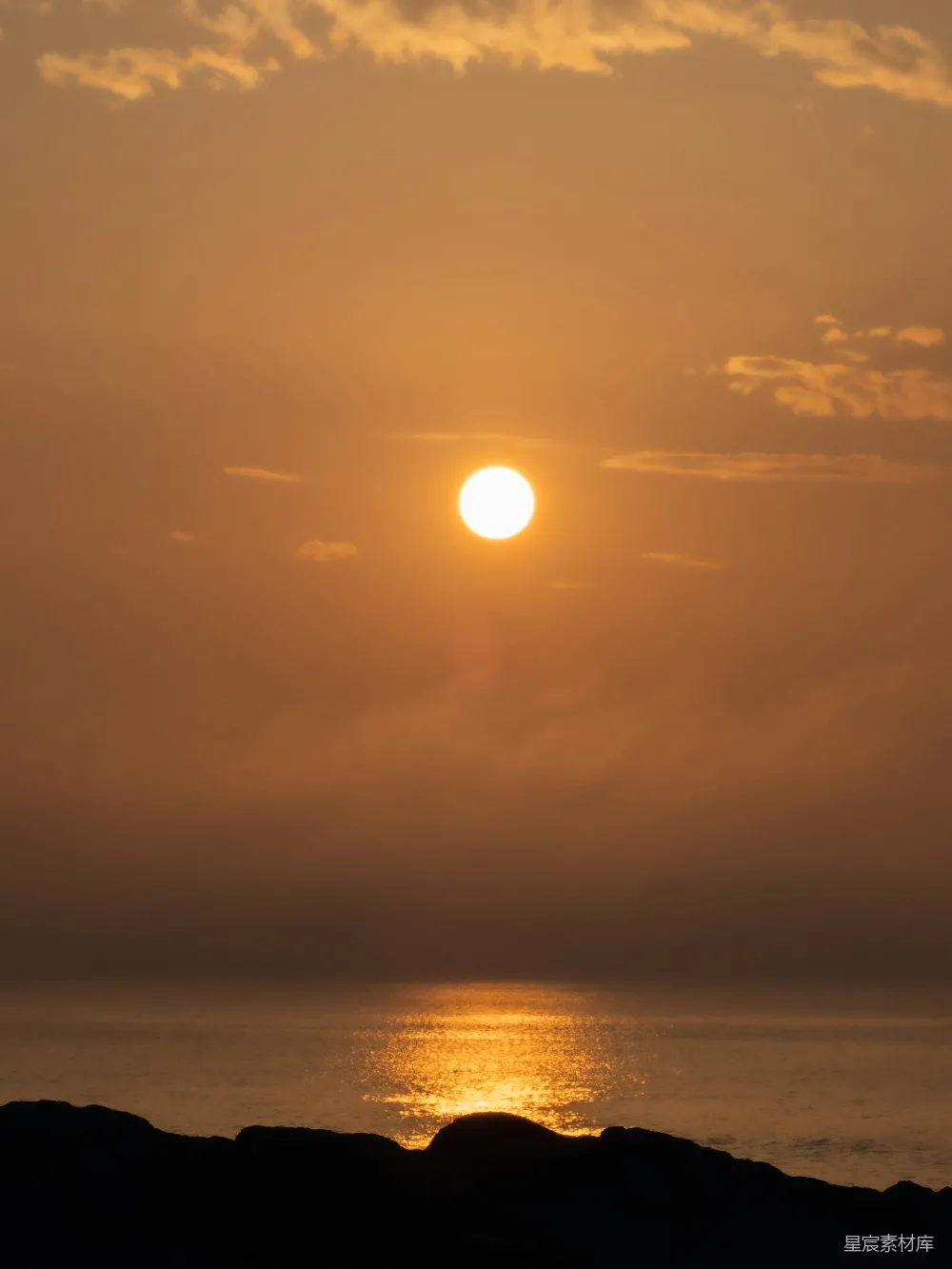 高清摄影  金色的太阳正缓缓沉落在平静的海平面上。