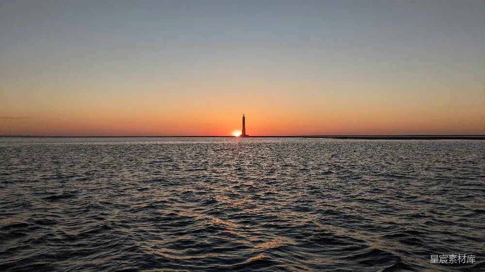 高清摄影  海面上灯塔的剪影在日落时分
