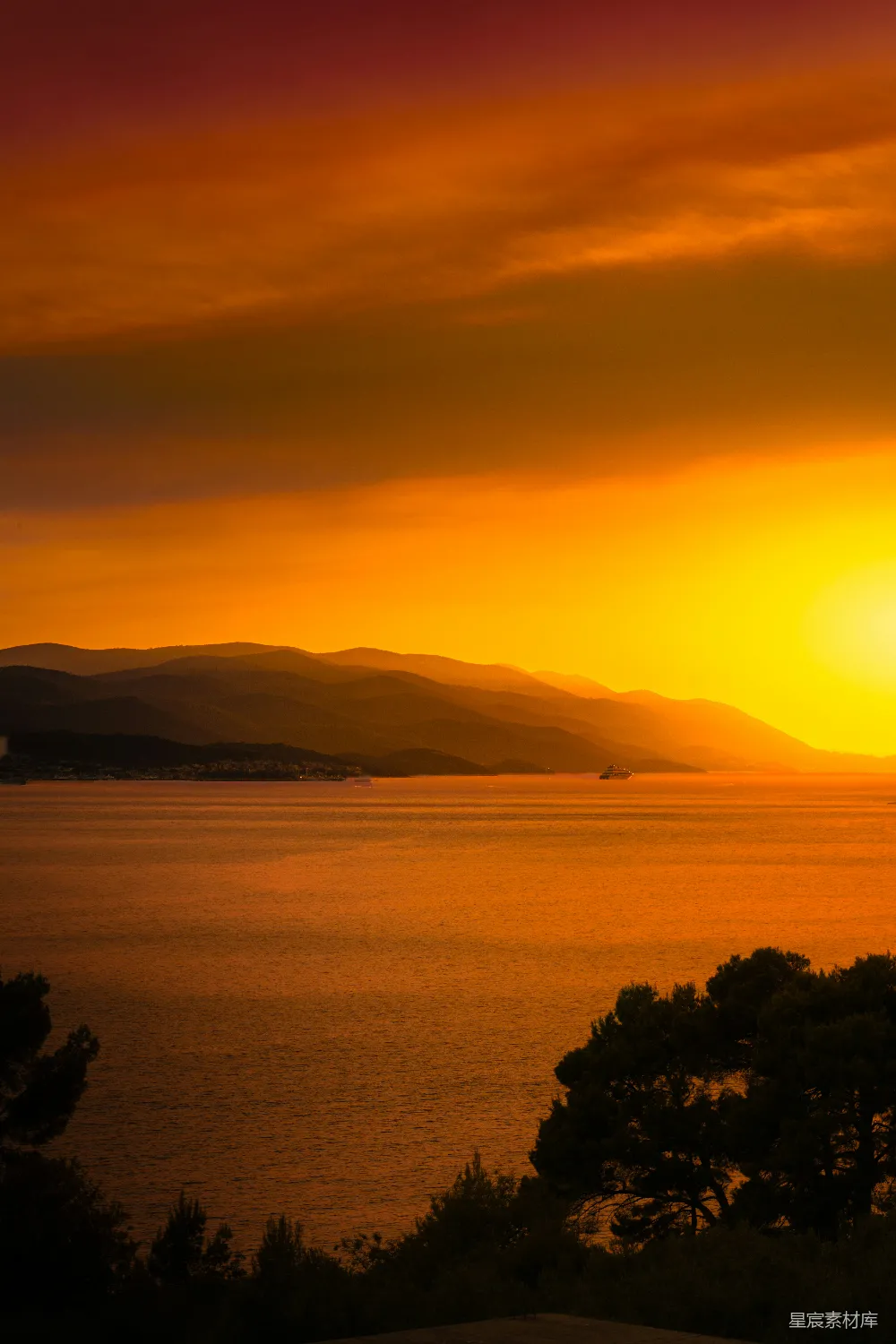 高清摄影  夕阳映照在水面上，背景是连绵的山脉。