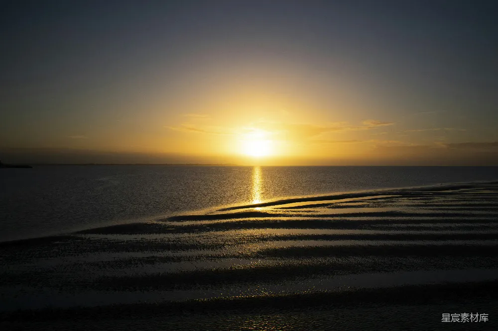 高清摄影  夕阳在海滩的水面上落下。