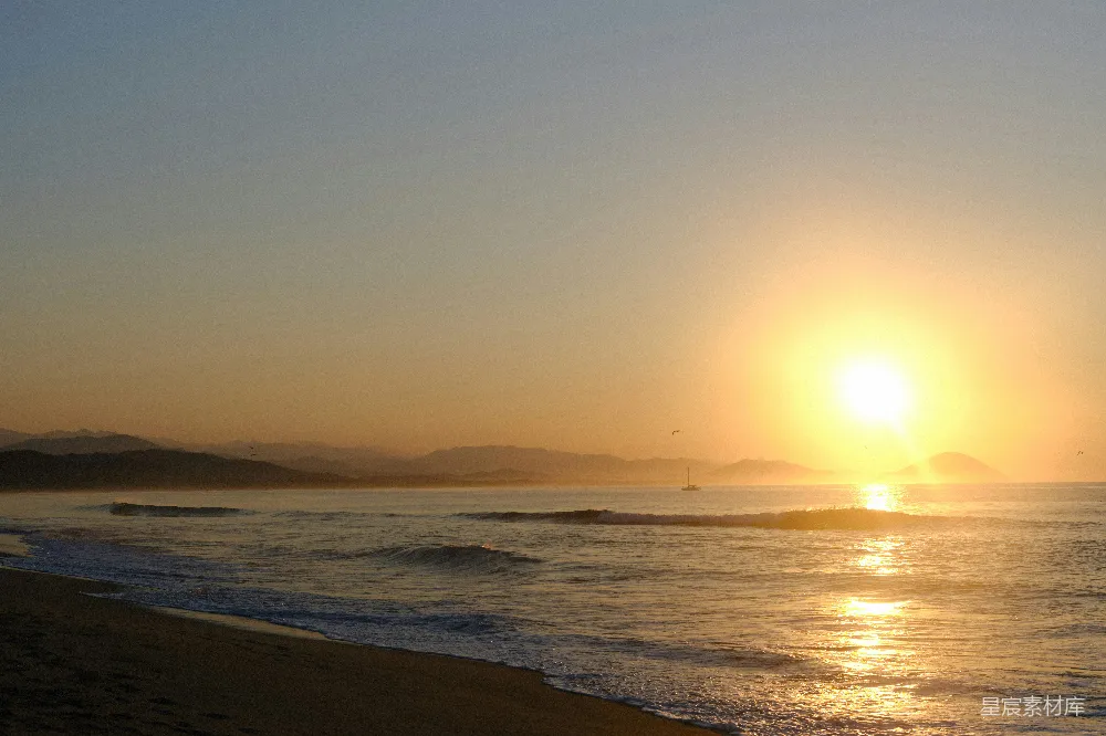 高清摄影 旅行 自然 壁纸 日落时分，海滩上空的夕阳正照在海面上。