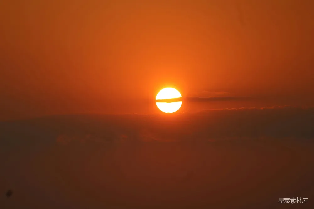高清摄影 自然 夕阳在橙色的天边，被薄雾笼罩的云层后落下。
