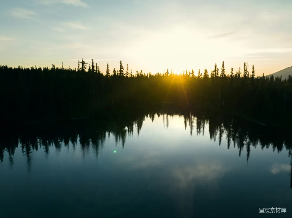 高清摄影  夕阳正在湖边树木环绕的湖面上落下。