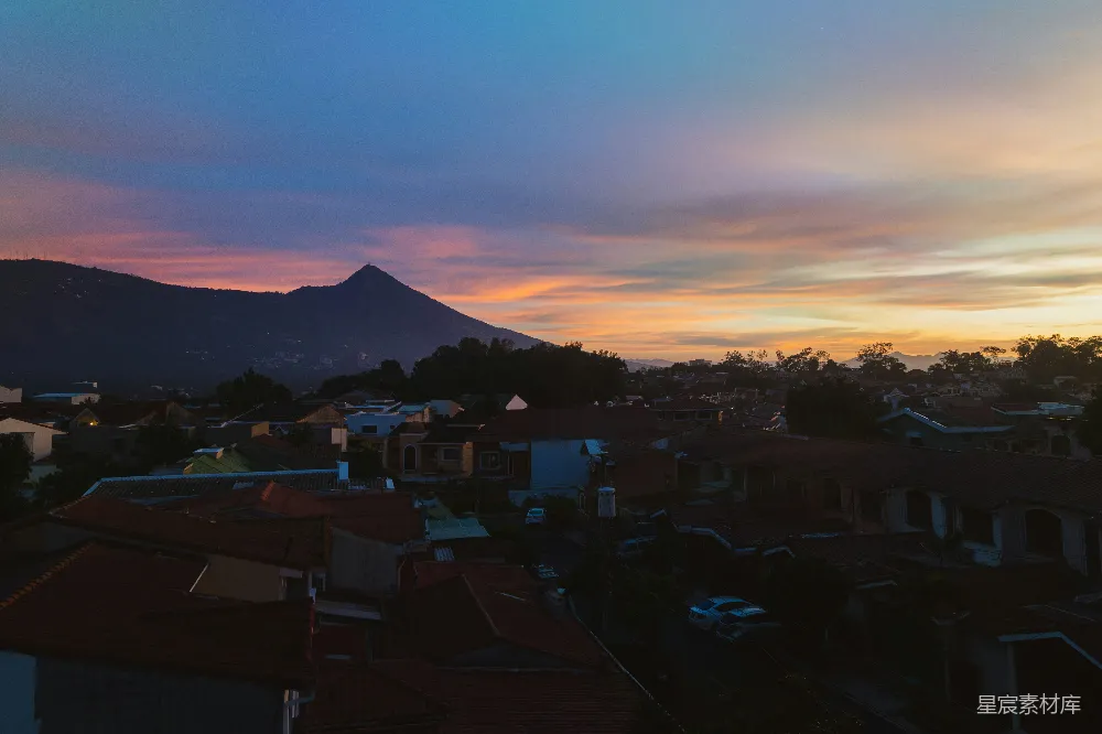 高清摄影  夕阳下的城市景观，背景中有山脉。