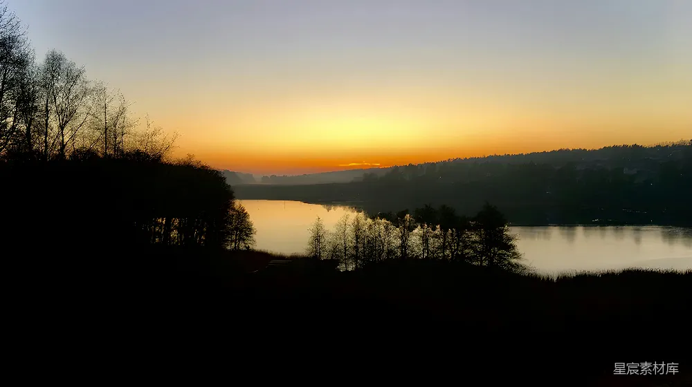 高清摄影  夕阳西下，湖面上树木倒映其中。