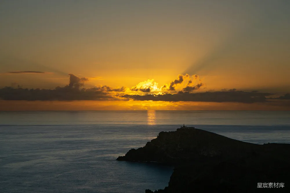 高清摄影  夕阳正落下，云朵漂浮在海面上。