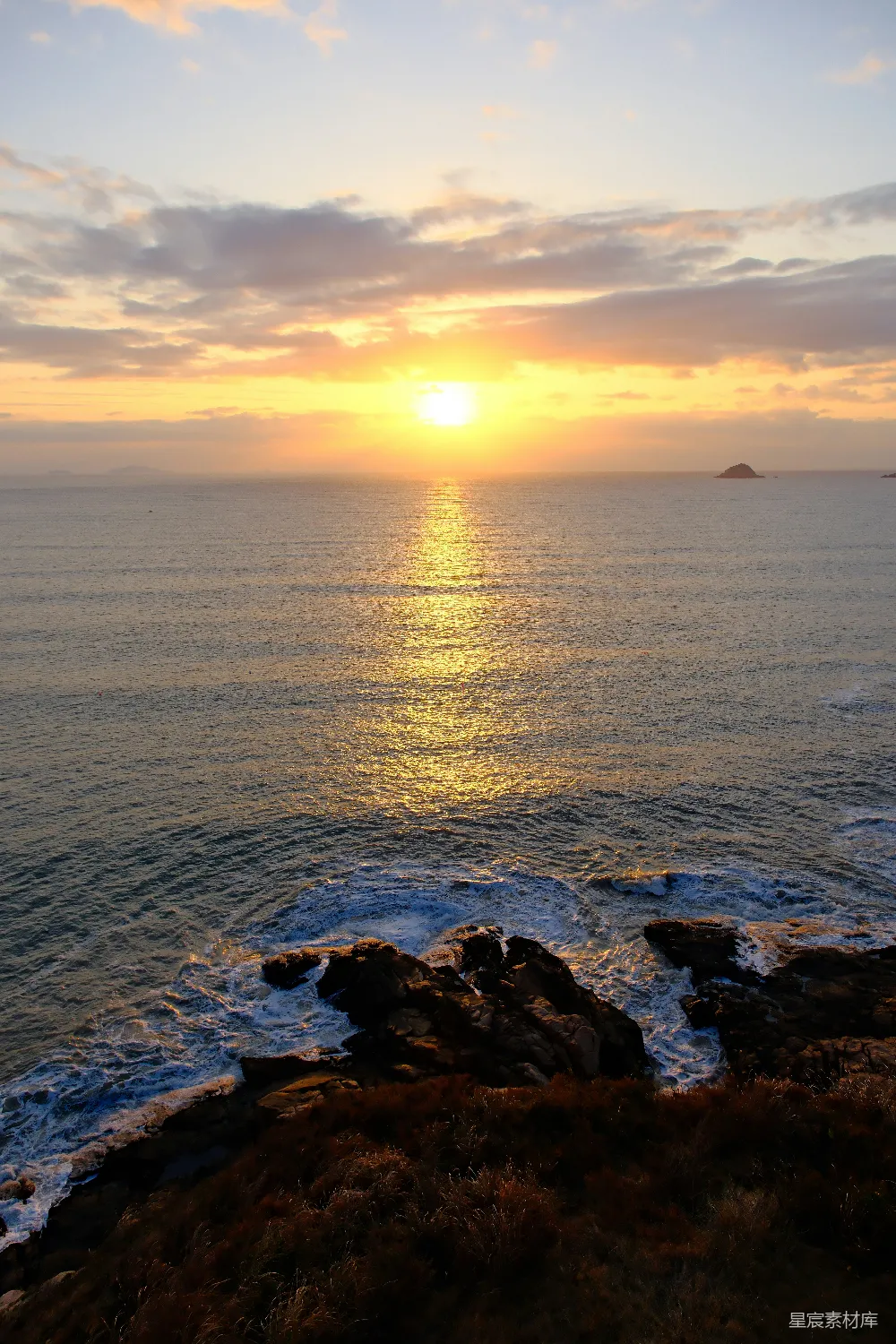 高清摄影  金色的夕阳洒在海洋上，岸边岩石嶙峋。