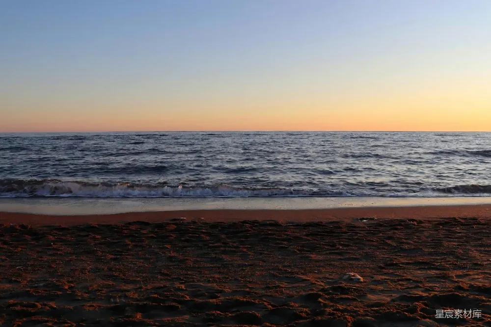 高清摄影  夕阳下，沙滩上波澜宁静的海浪