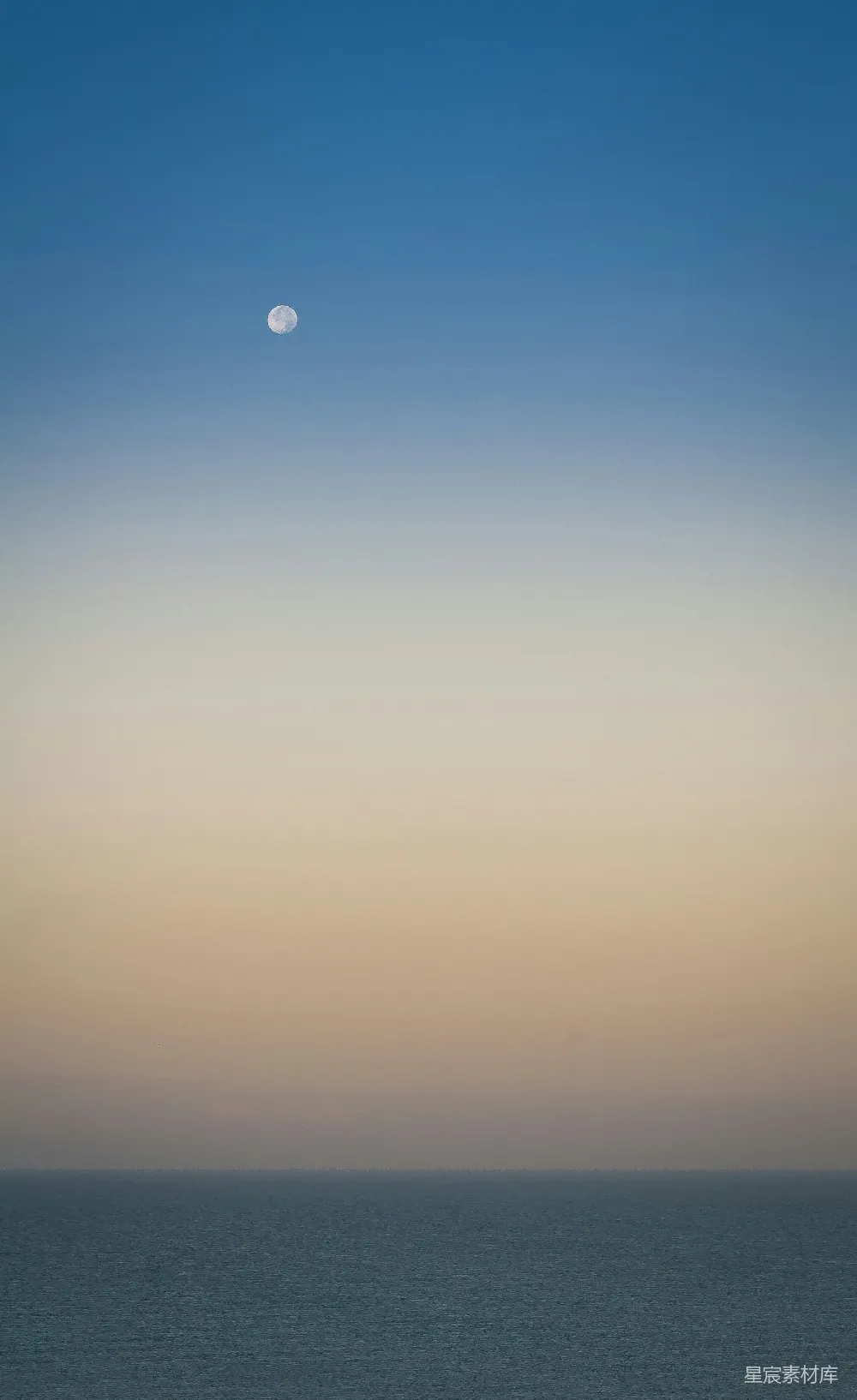 高清摄影  海景，月亮挂在天空中。