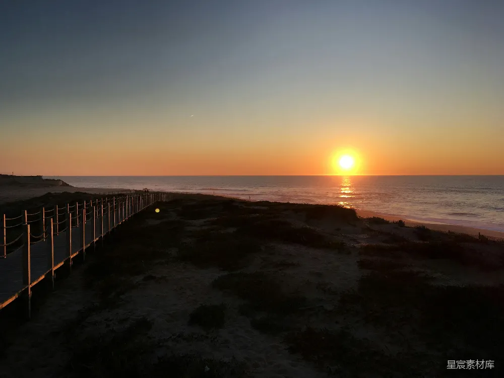 高清摄影  夕阳西下，海面上有一条栈道。