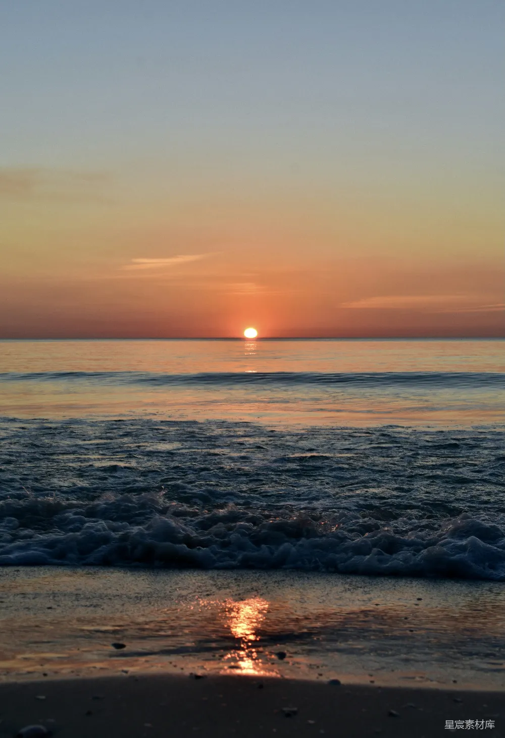 高清摄影 自然 夕阳正落于海面，海滩上一片宁静。