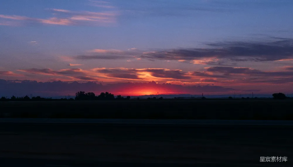 高清摄影  夕阳正映照在田野的地平线上。