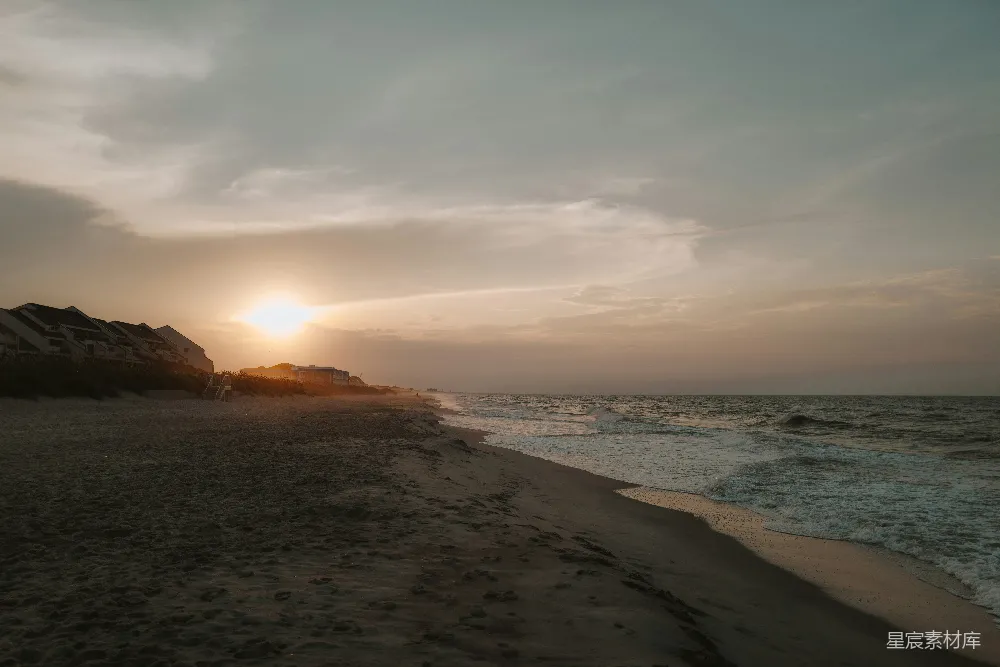 高清摄影  夕阳正在海面上落下，海滩上一片宁静。