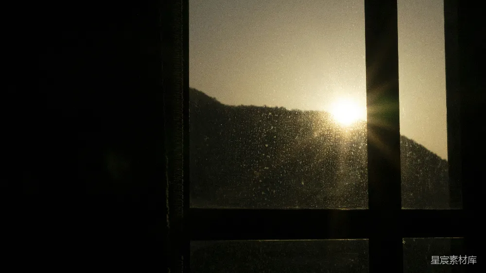 高清摄影  夕阳透过窗户照在山峦上。