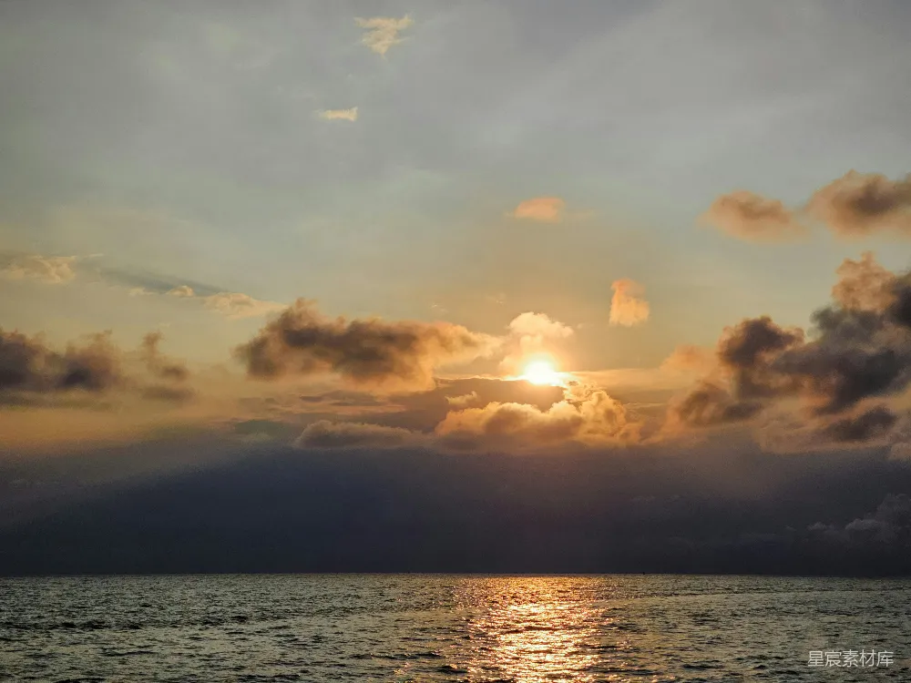 高清摄影  在一个多云的天气里，夕阳正照耀着海面。