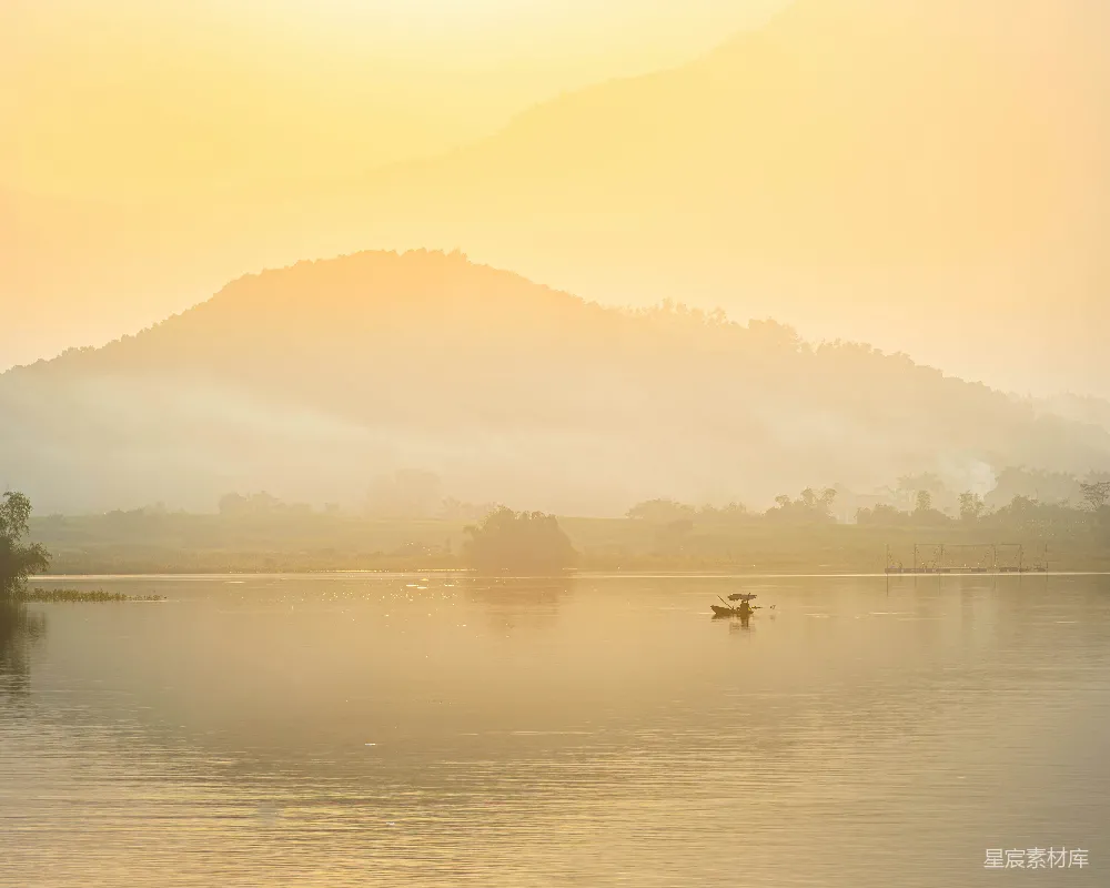 高清摄影 自然 一艘船在平静的湖面上，夕阳下群山环绕。